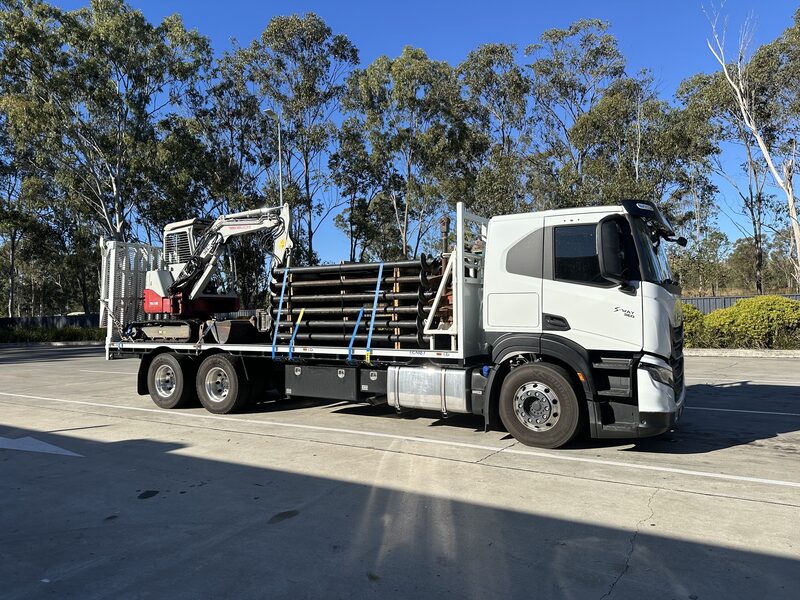 Core Screw Piling truck loaded with steel screw piles and a mini excavator, ready for delivery to site